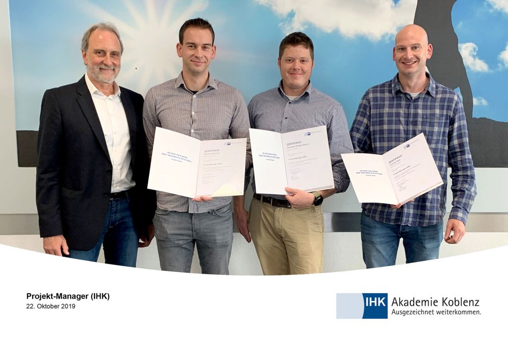 Projekt-Manager posieren mit Zertifikat in der Hand für die Kamera