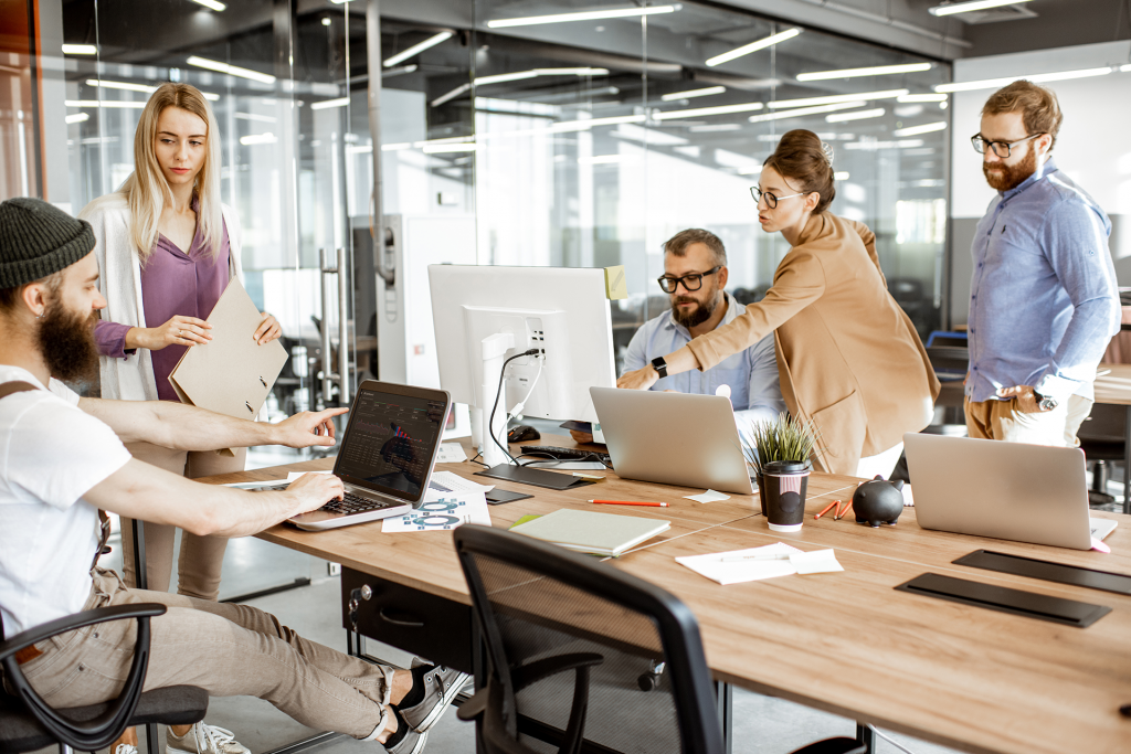 Junge Menschen arbeiten in agilem Unternehmen miteinander und sind glücklich